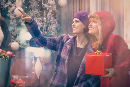 two young woman shop during christmas time in a cityscapeの写真素材