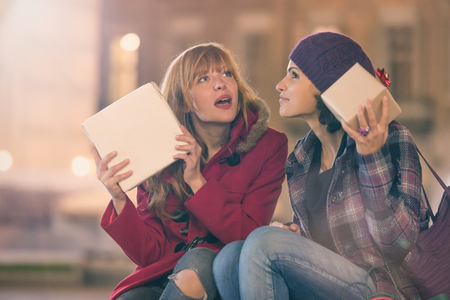 two young woman shop during christmas time in a cityscapeの写真素材