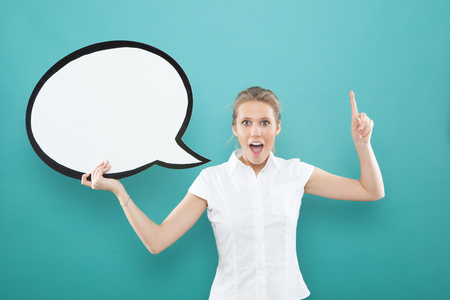 pretty young blond caucasian woman pointing finger with comic baloon  on blue backgroundの写真素材