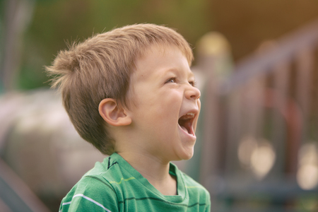 happy smiling blond caucasian kid outdoor portrait at parkの写真素材