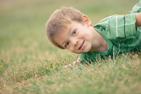 happy smiling blond caucasian kid outdoor portrait at parkの写真素材