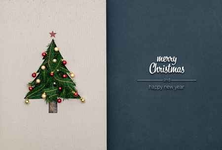 Merry Christmas and happy new year greetings in vertical top view dark blackboard with natural eco decorated christmas tree pine in cardboard.Xmas winter holiday season social media card backgroundの写真素材