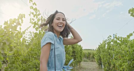 Romantic love couple, woman smiling running and walking near vineyard at sunset or sunrise.Warm sun back light.Following POV point of view.Friends italian trip in Umbriaの写真素材