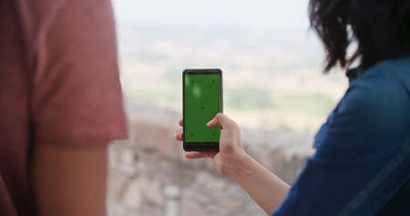 Romantic couple taking a selfie or using green screeen smartphone device in rural town of Assisi.Portrait medium shot.Friends italian trip.の写真素材