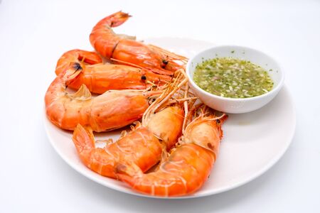 Top view and close up: Grilled shrimp on white dish and spicy seafood sauce (Thai style food) in bowl isolated on white background.の写真素材
