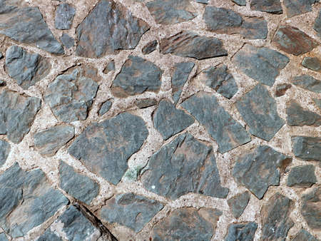 Stone old wall from huge blocks.The space between the stones is filled with cementの写真素材