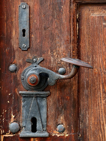 Old door handle on the brown old doorの写真素材