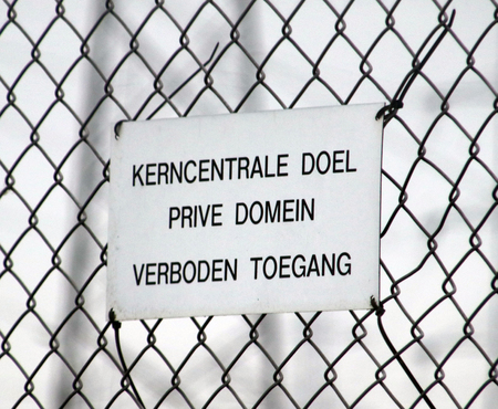 Sign on the fence of the nuclair plant of Doel in Belgium,that behind fence all is private property and no trespassing in dutch language.の写真素材