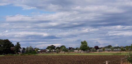 Cumulus rain clouds abov meadows and fields in Wezep in the Netherlandsの写真素材
