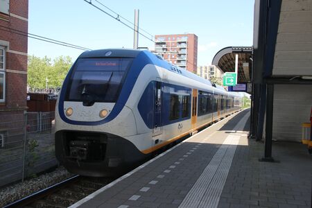 Railroad station of Woerden between Gouda and Utrecht with SLT train along platform
