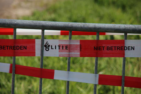 Red and white barrier tape of the Dutch police on a barrier at a crime sceneのeditorial素材