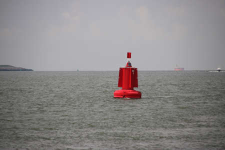 Red buoy as a waterway marking on the Nieuwe Waterweg canal in the port of Rotterdamのeditorial素材