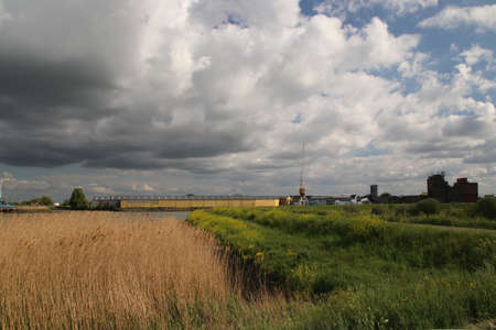 Dark storm clouds over the Hollandsche IJssel river near Oudekerk aan den IJssel near wood trade Heuvelmanのeditorial素材