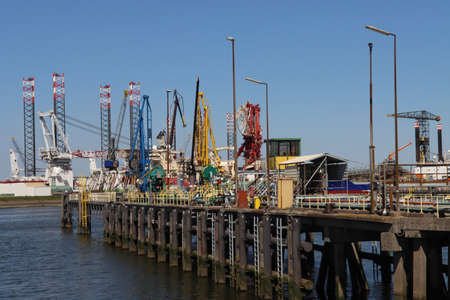 Mechanical lifting arms on a jetty at Crude oil storage terminal Vopak in the Welplaat harbor in the...