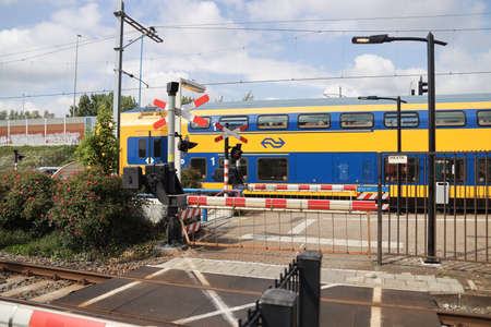 Closed Barriers at railroad station Zoetermeer Oost with DDZ train