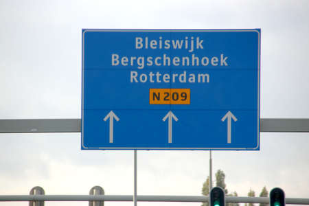 Direction sign in blue and white heading Rotterdam and Bergschenhoek on N209のeditorial素材
