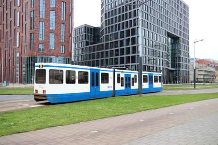 White and blue streetcar in the streets of Amsterdam in the Zuidas district in the Netherlandsのeditorial素材