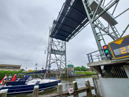 Steel lift bridge over the Gouwe at Waddinxveen open for high-masted ships in the Netherlandsのeditorial素材