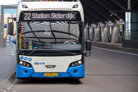 Blue and white articulated bus at bus stop Amsterdam Central Station.のeditorial素材