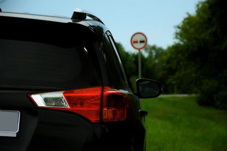 Black car on the roadside and sign on the backgroundの写真素材
