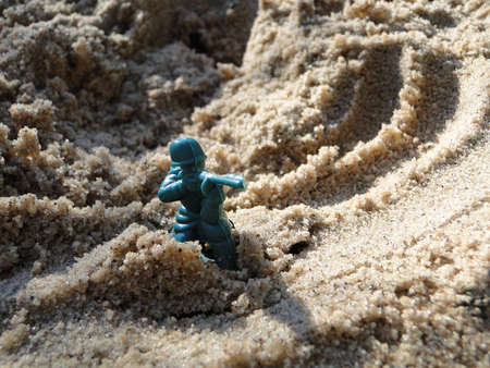 Toy green soldier in the sand box.の写真素材