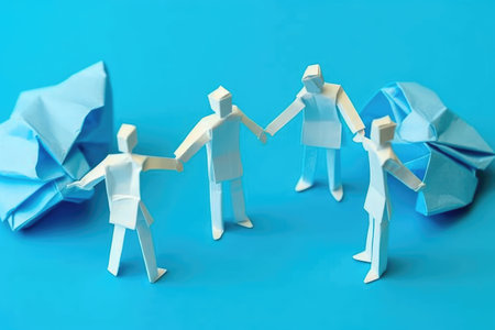Paper people holding hands on a blue background. Conceptual photo of teamworkの素材