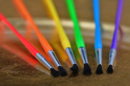 Colorful Baint Brushes on a gold paletteの写真素材