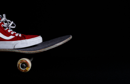 Photo, dark background. Skateboard, gym shoes. Sport, active lifestyle.の写真素材