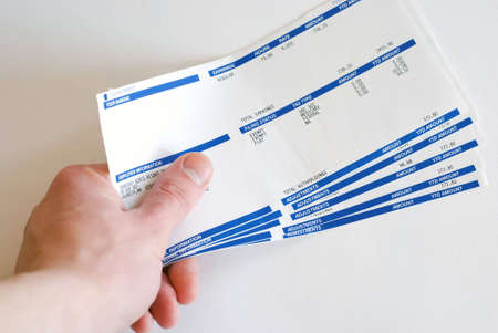 Male hand holding pay cheques checks in his hand on white backgroundの写真素材