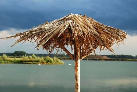 Alone standing parasol (umbrella) on abandoned beachの写真素材