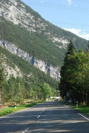 Highway in Austrian Alps with mountain and pines beside the roadの写真素材