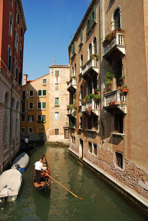 Gondola in venetian canal between buildingsの写真素材