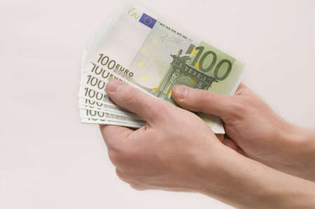 Male hands holding money (euro banknotes) isolated on white backgroundの写真素材