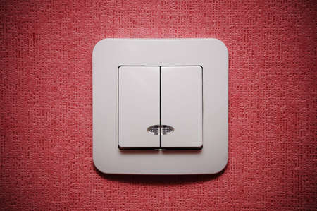 Double light switch against red wall closeupの写真素材