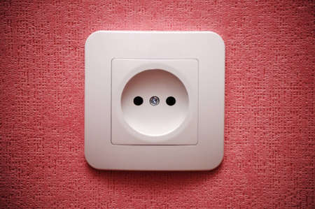 Electric plug connector (outlet) on red wallの写真素材