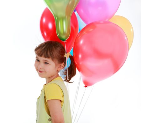 little girl holding colorful balloons on a white backgroundの写真素材