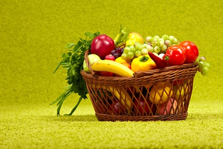 Fresh vegetables in basket  on green background の写真素材