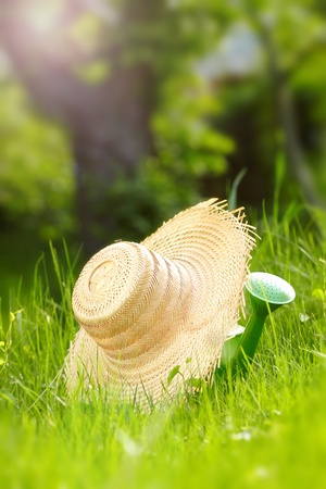 Gardening tools  Hat and can in green grassの写真素材