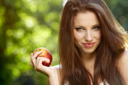 Woman with apple in gardenの写真素材