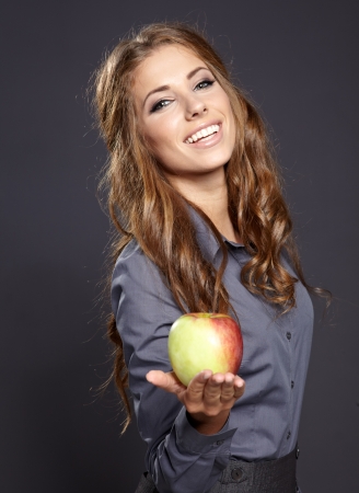 Closeup portrait of cute young business woman smiling at studio. Eating  apple  の写真素材