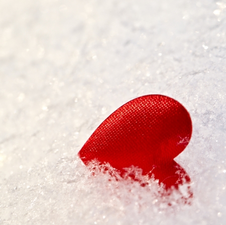 Red heart on snow の写真素材