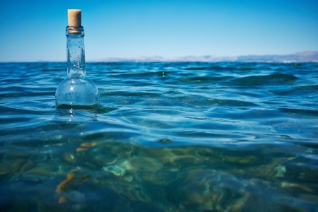 Bottle with a message in water の写真素材