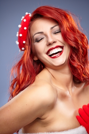 Christmas Santa hat redhead woman portrait   Smiling happy girl on blue  background  の写真素材