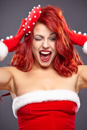Christmas Santa hat redhead woman portrait   Smiling happy girl on blue  background  の写真素材