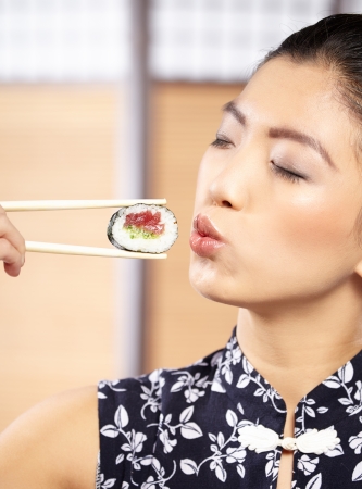 Beautiful young woman eating sushi  Shallow depth of field, focus is on the eyes  の写真素材