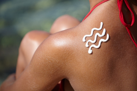 girl back with sunburn and wave of sun lotion の写真素材