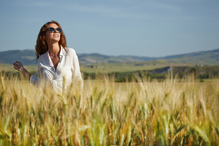 Woman in wheat field enjoying, freedom concept の写真素材