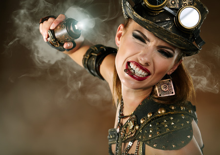 Portrait of a beautiful steampunk woman over smoke background. の写真素材