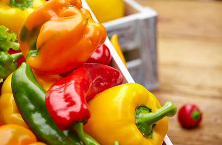 Colorful peppers in a wooden boxの写真素材