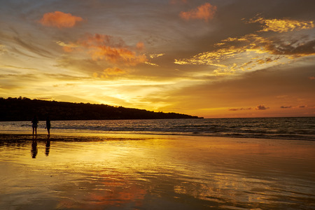 silhouettes of couples on the beach in sunsetの写真素材